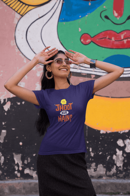 Unisex "JHOOTH AUR MAIN?" purple t-shirt worn by a woman in front of vibrant graffiti art