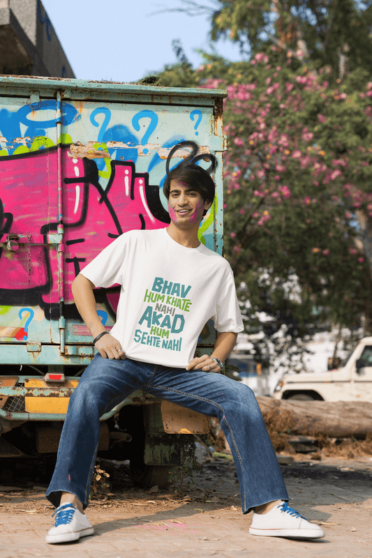 Unisex white T-shirt with "BHAV HUM KHAATE NAHI" design worn by a smiling person in casual outdoor setting