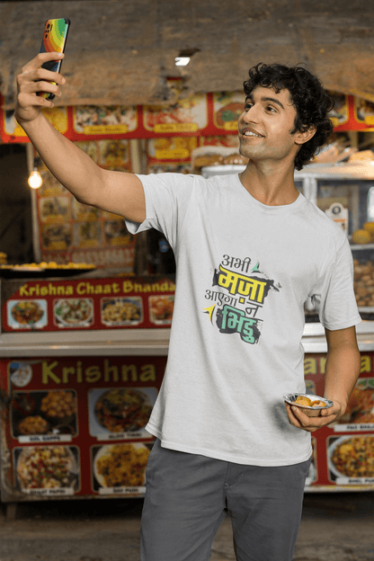 Man wearing "ABHI MAZA AAYEGA NA BHIDU" unisex T-shirt taking a selfie in front of a food stand