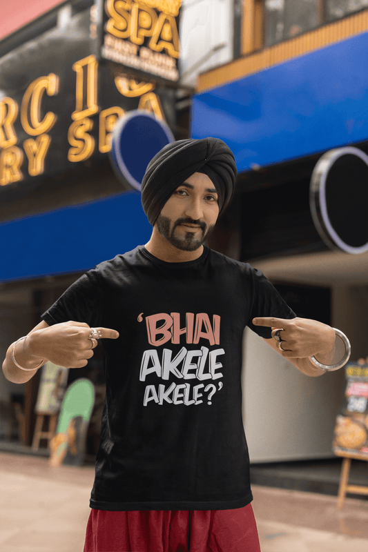 Man wearing a black round neck T-shirt with "Bhai Akele Akele" text in front of a storefront