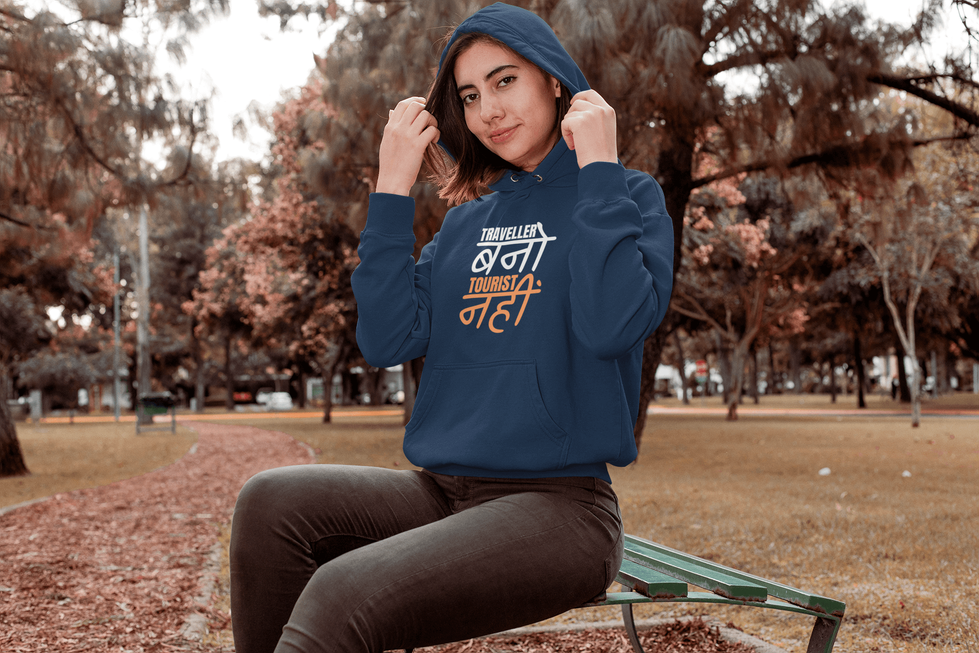 Model showcasing a Traveller Hooded Sweatshirt in a park, blending style and comfort for winter wear.